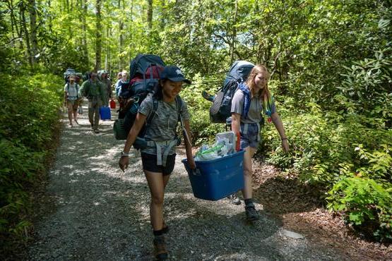 bet8九州登录入口的学生背着背包在森林小径上徒步旅行